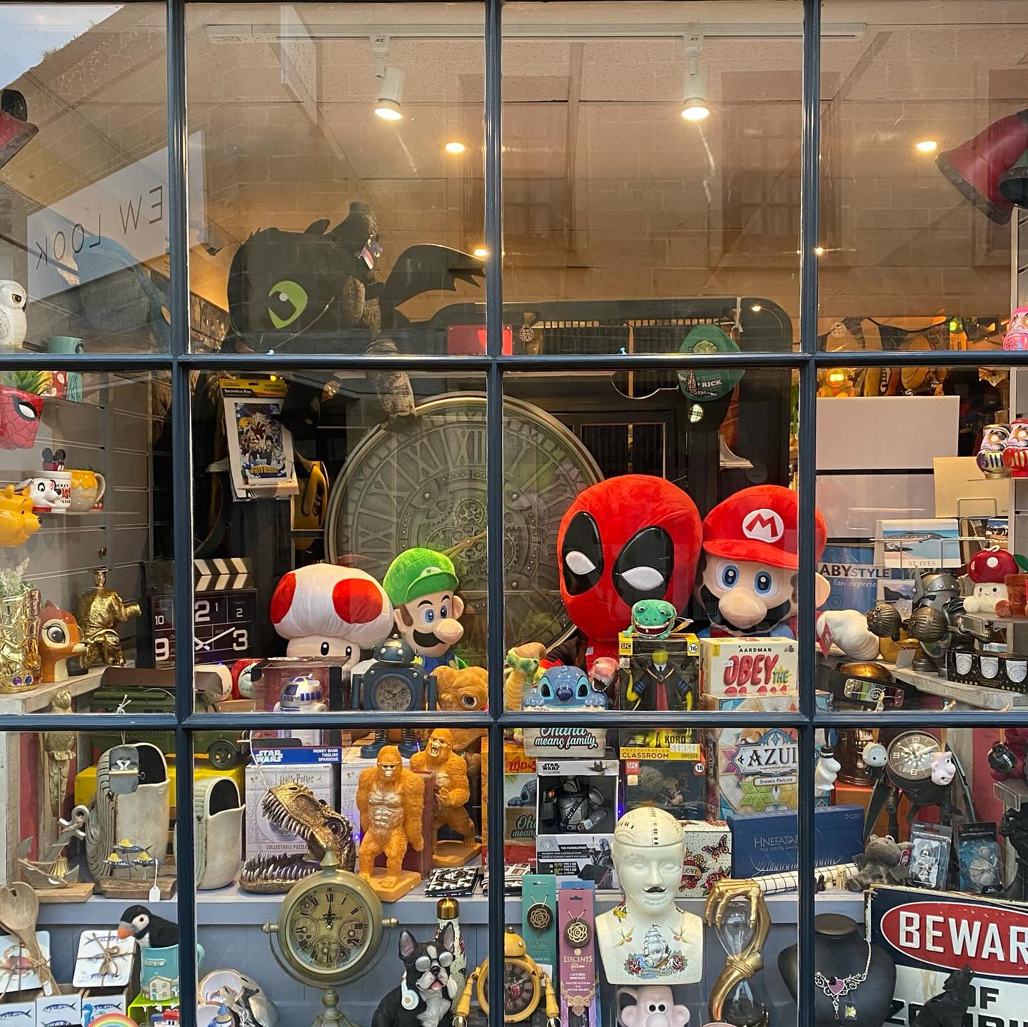 A close up of the window of the Happy Piranha store from outside, full of colourful items.