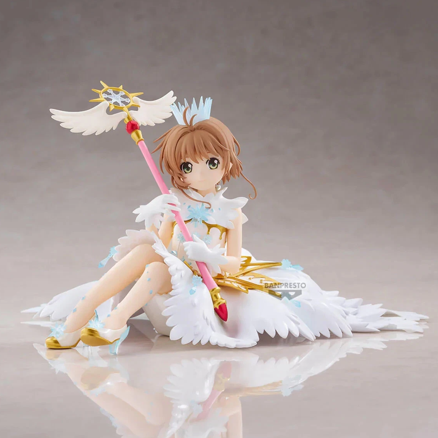 A collectible anime figurine of Aisaka Kamishina from Cardcaptor Sakura, depicted in her White-Close-Close outfit with angel wings, holding a pink and gold staff, posed on a reflective gray surface | Sakura Kinomoto: Cardcaptor Sakura Clear Card Figure | Happy Piranha