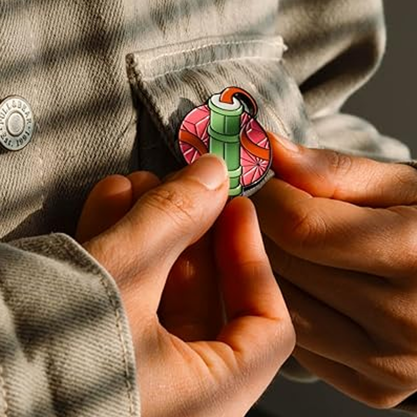 Person wearing a colorful bamboo-themed pin on a jacket