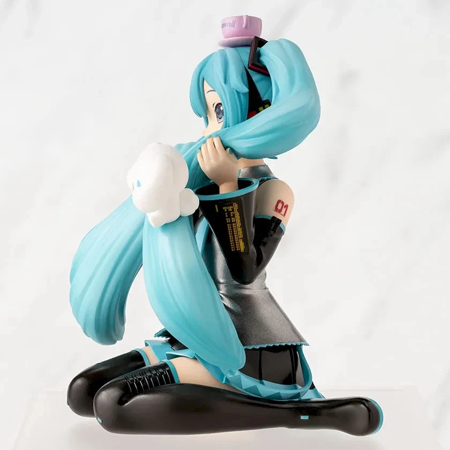 A collectible figurine of Hatsune Miku kneeling in a playful pose, featuring her signature turquoise twin-tails, black and gray outfit, and white cloud accessory, set against a light gray marble background | Hatsune Miku x Cinnamoroll Paprio Figure Mofutto ver. | Happy Piranha