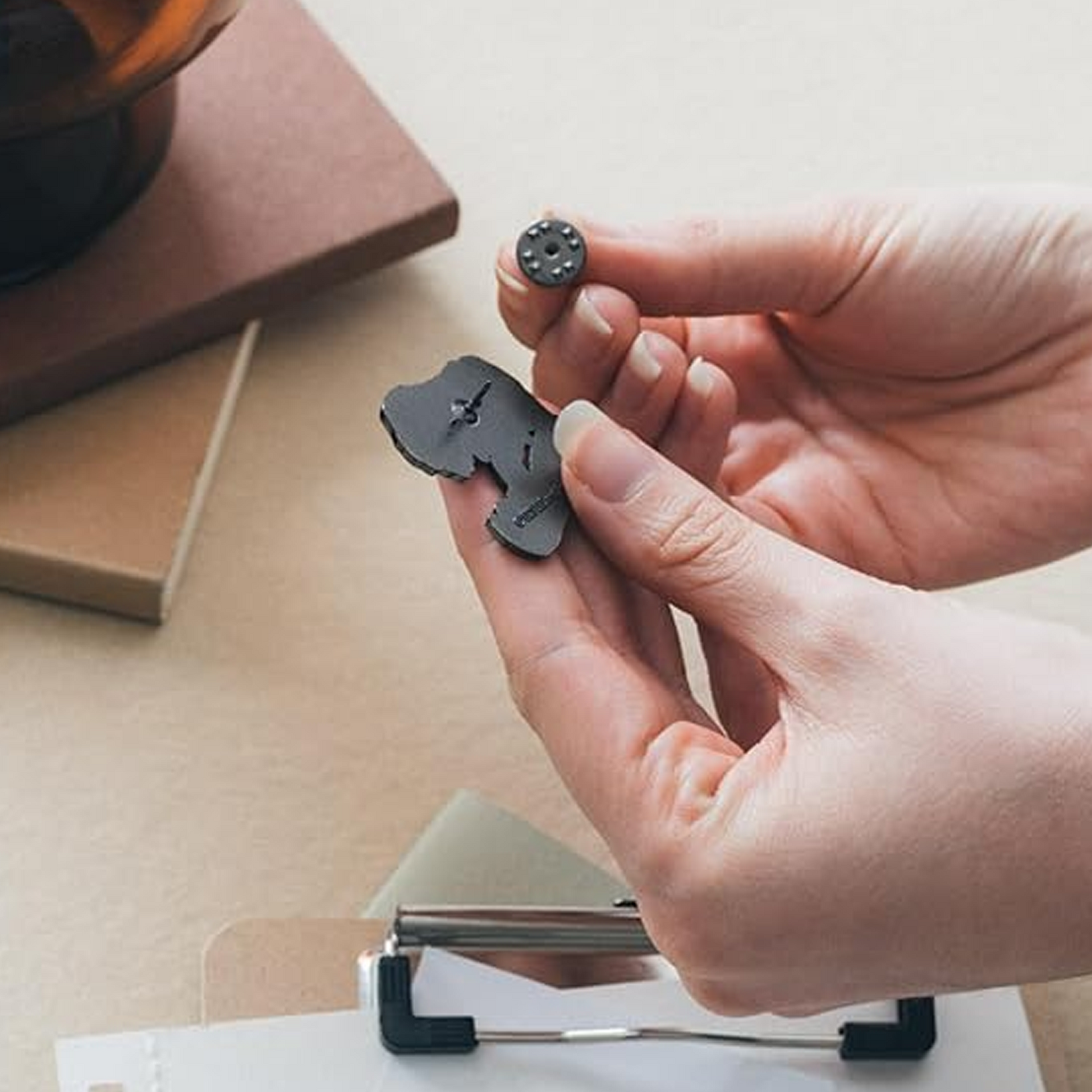 Person Holding a Jurassic Park Pin Badge and Showing the Metal Safety Backer.
