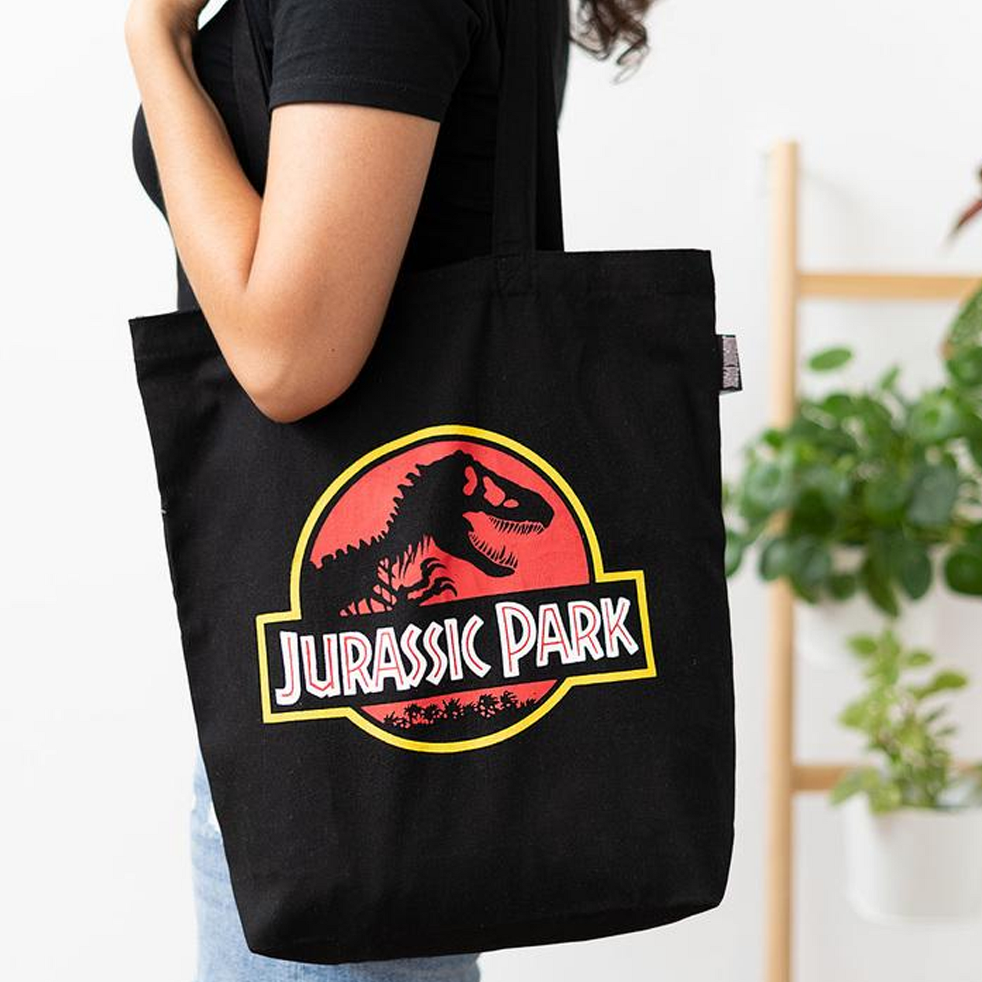 Jurassic Park T-Rex Logo Design Tote Bag on a Person's Shoulder | Happy Piranha