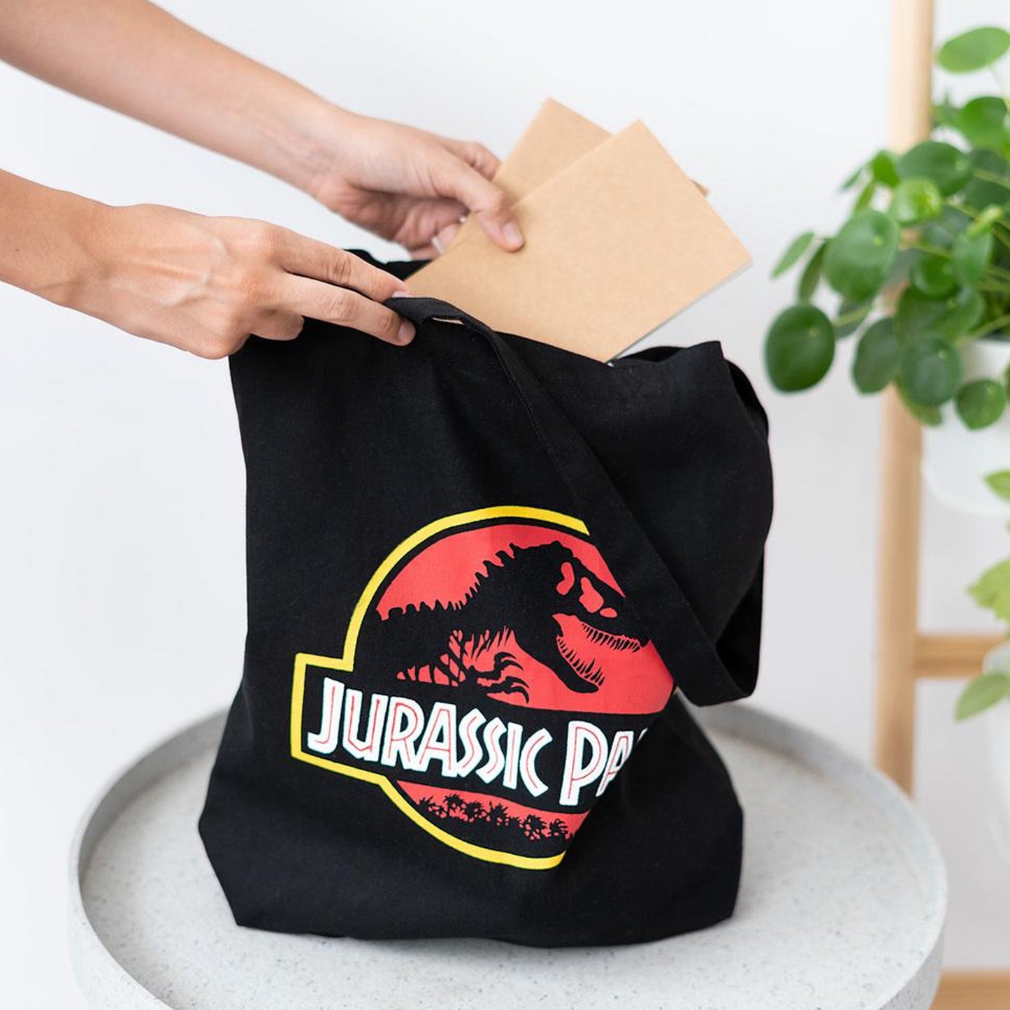 Jurassic Park T-Rex Logo Design Tote Bag on a Table | Happy Piranha