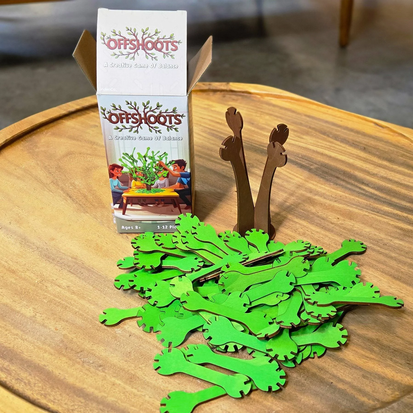 OffShoots: A Balancing Board game set up on a Wooden Table Ready to Play Beside the Box | Happy Piranha