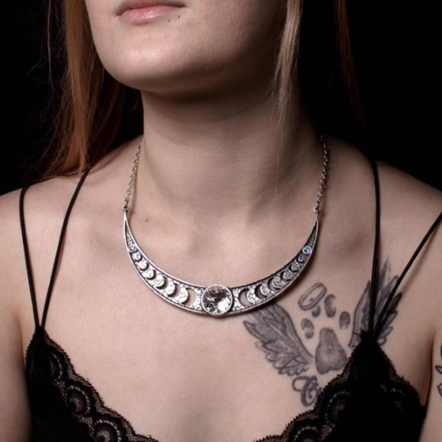 A Close Up of a Woman with a Tattoo Wearing the Priestess of Ishtar Moon & White Crystal Gothic Design Necklace on a Dark Background | Happy Piranha
