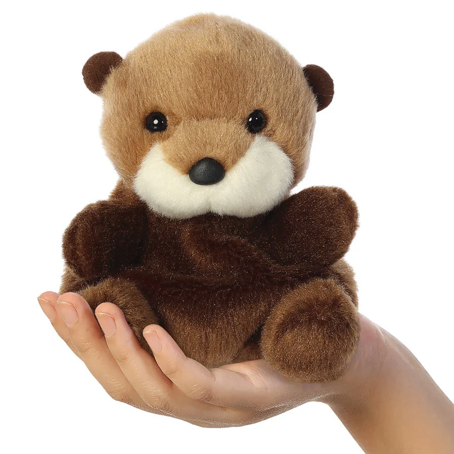 Selena the Sea Otter Palm Pal Plushie Soft Toy in a Child's Hand on a White Background | Happy Piranha 