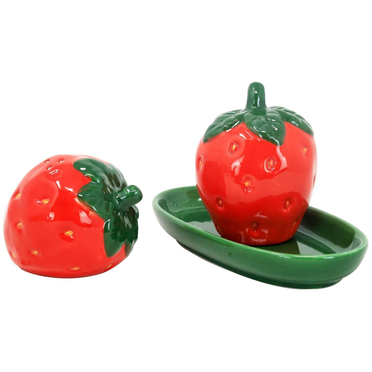 Strawberry Pair Ceramic Salt & Pepper Shaker Set on a White Background With One on the Table and One on the Green Dish | Happy Piranha