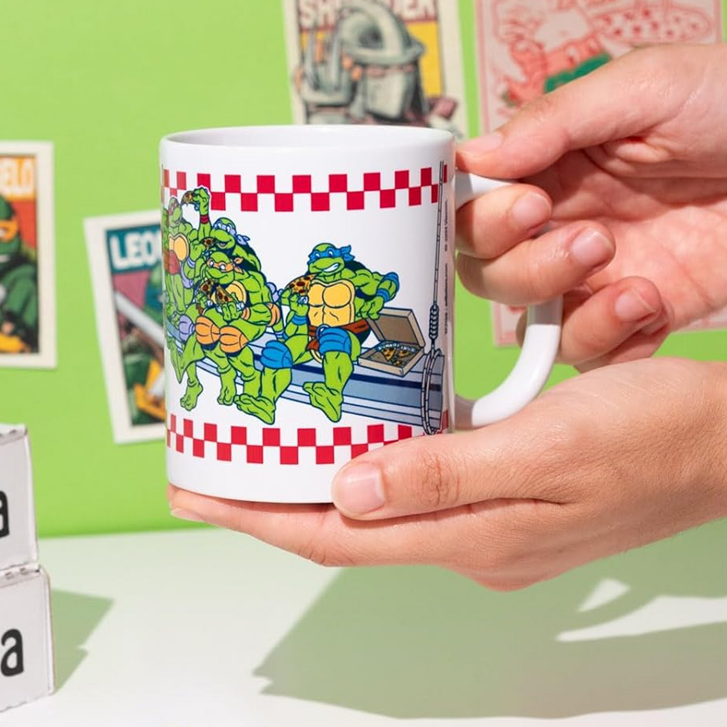 Teenage Mutant Ninja Turtles Pizza Design 350ml Ceramic Mug Being Held in a Person's Hands with a Green Background | Happy Piranha
