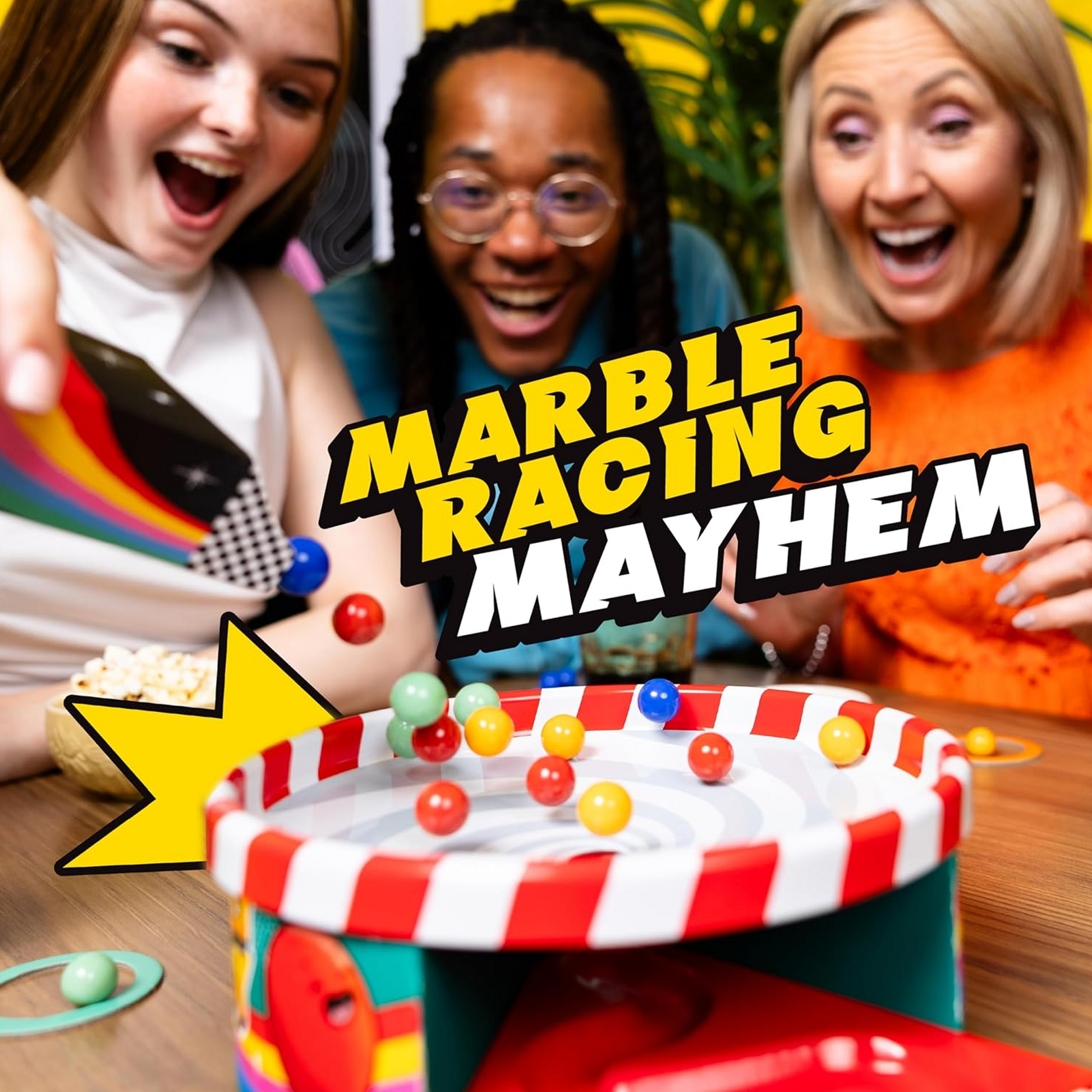 A group of 3 People Playing Whirly Derby Marble Racing Board Game on a Wooden Table and Smiling | Happy Piranha