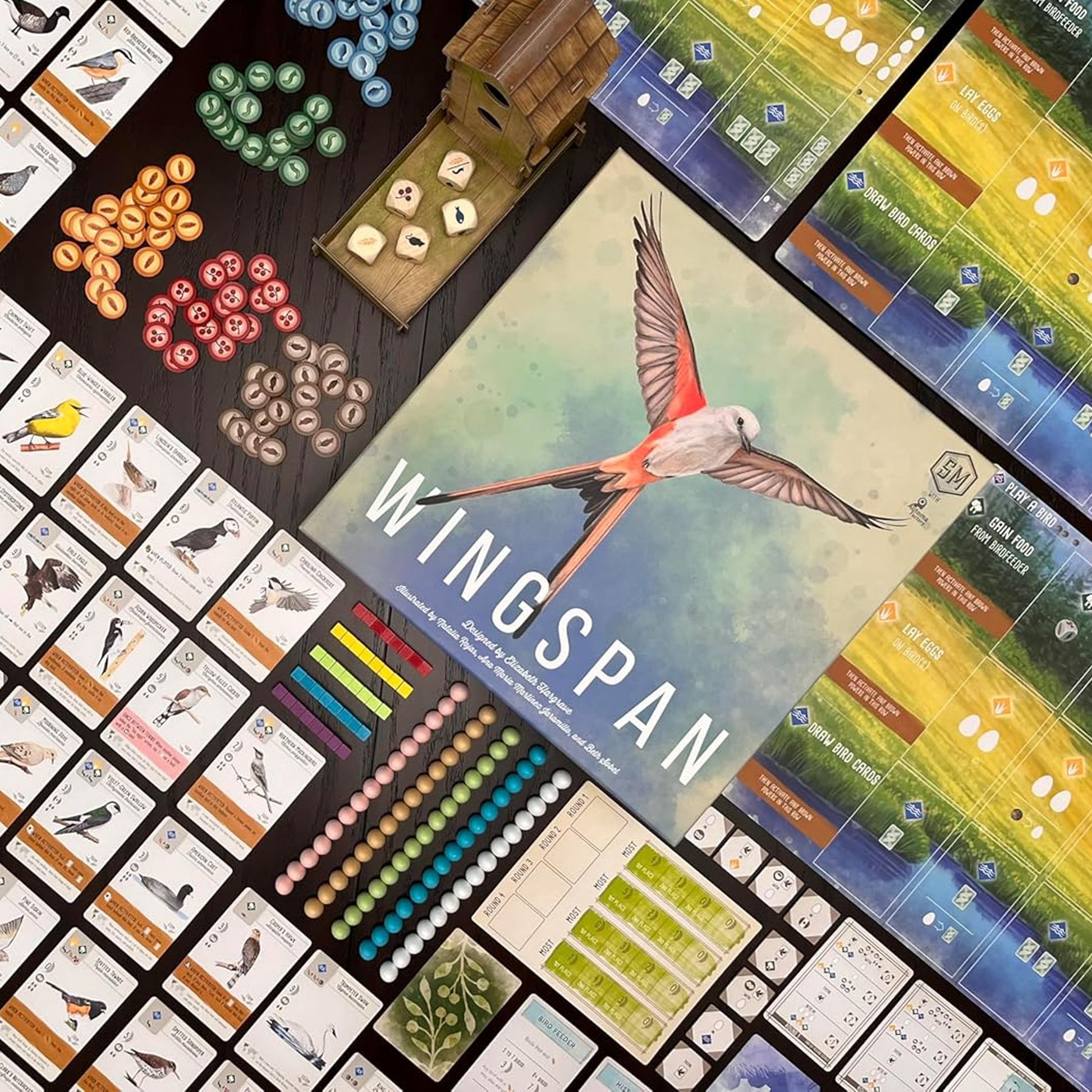 Wingspan Board Game Box  Viewed from Above, Surrounded by Colourful Components and Cards | Happy Piranha