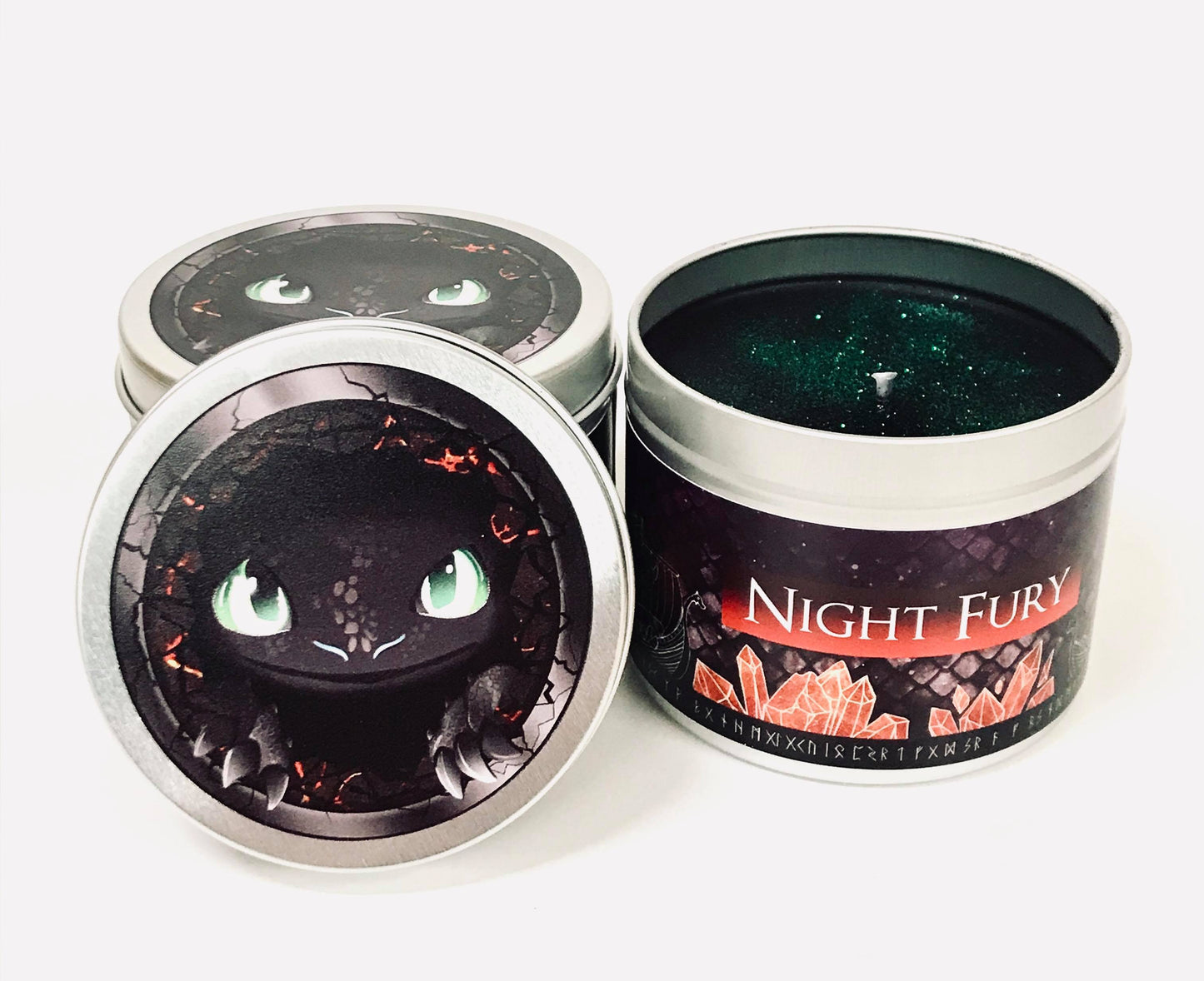 Night fury scented candle with its lid off, black wax and green glitter.