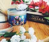 Iskari scented candle with lid off and the Last Namsara book.