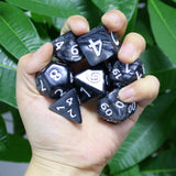 Giant Pearl Poly Dice Set (Black) in a Persons Hand | Happy Piranha
