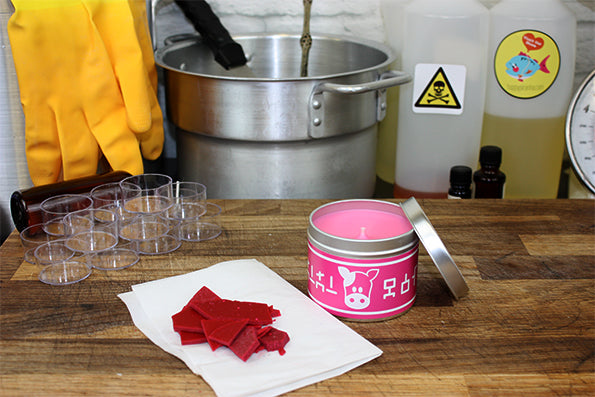 zelda lon lon pink mil scented candle with lid off next to wax.