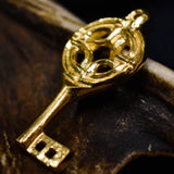 Viking Period Gold Plated Pewter Key Pendant Resting on Some Wood | Happy Piranha